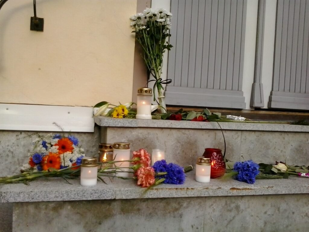 Flowers and vigil candles placed at the doorsteps of Embassy of Netherlands to Estonia (close up).