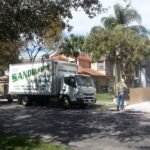 A&B Sandblasting truck in front of a South Florida home while a crew member blasts the driveway