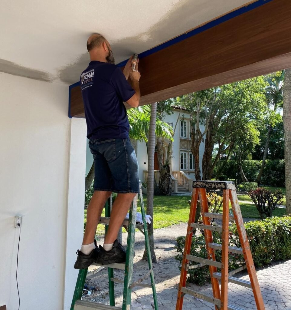 Architectural Foam Florida installer in a company shirt setting a foam beam at a home entrance